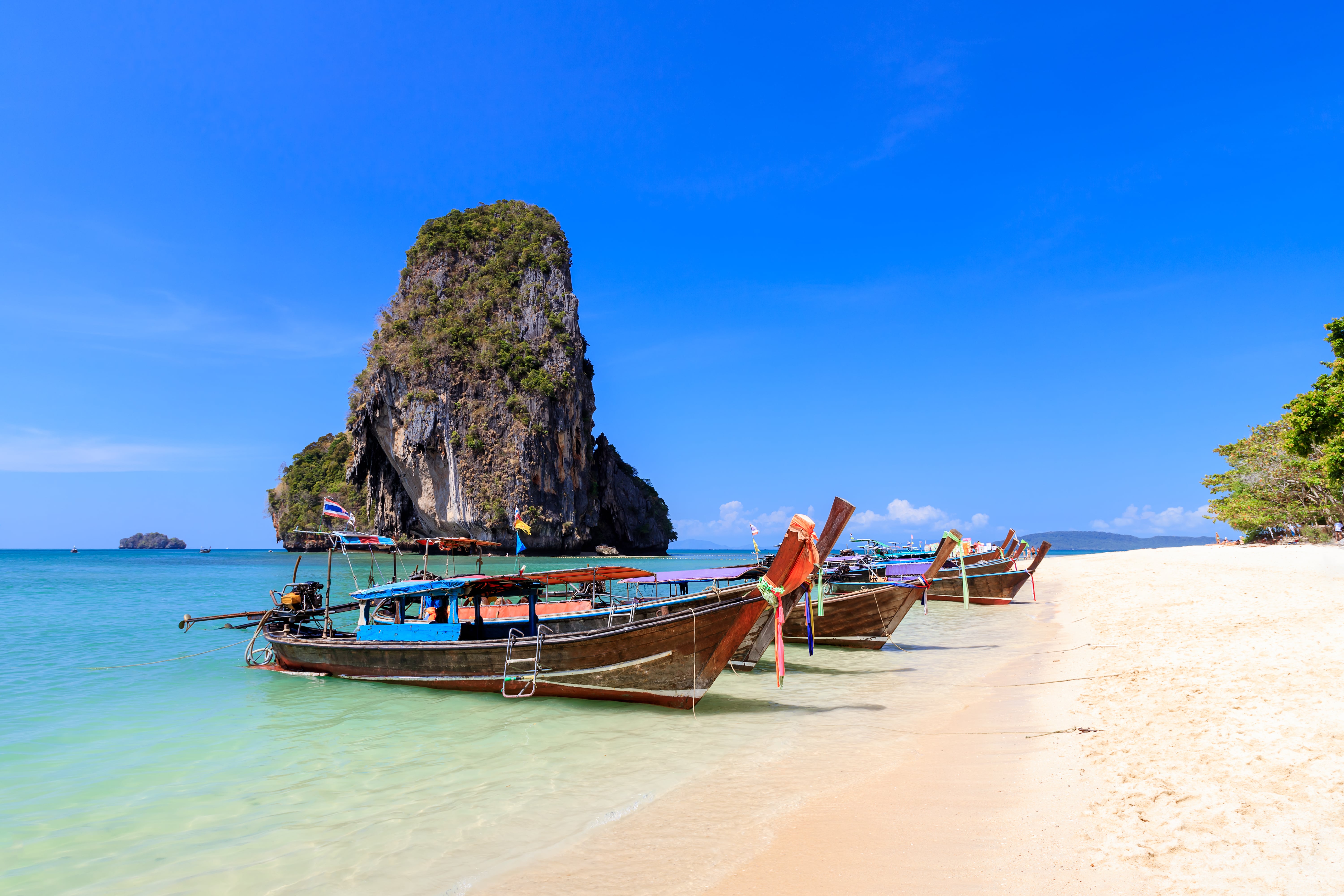bote de cola larga y agua de mar turquesa cristalina con acantilado de piedra caliza y montana en phra nang beach krabi tailandia min